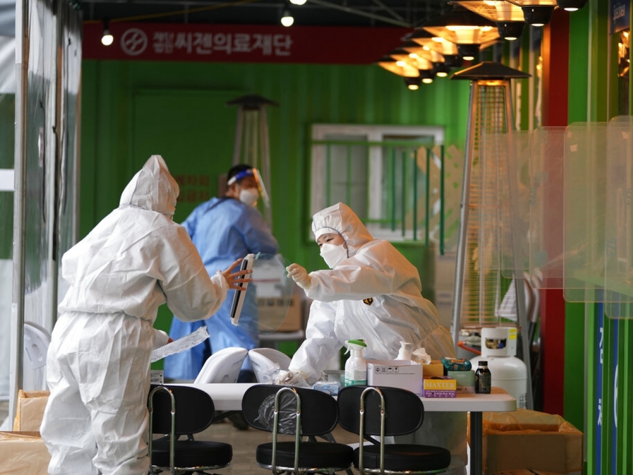 在首爾，有防疫人員進行檢測工作。（美聯社）